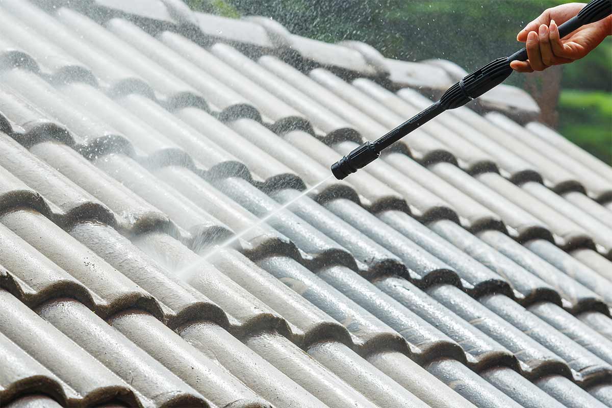 Roof cleaning team rinsing a roof